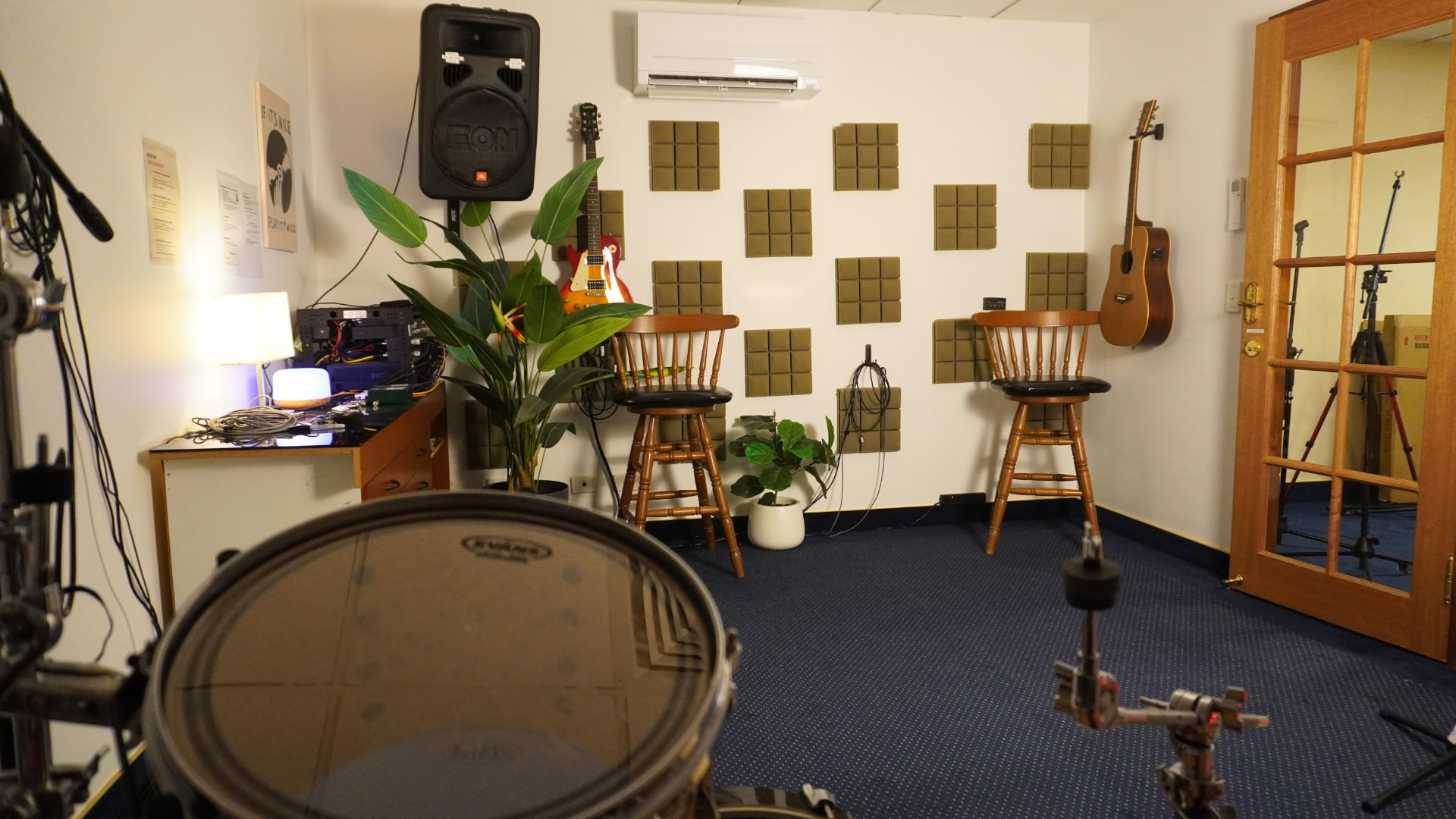 Wide view across the IEM rehearsal room from behind the drum kit